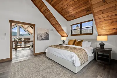 a bedroom with a large bed and a wooden ceiling at Rocky Mountain Gem! Two Large patios, Fireplace and Private Jacuzzi in Estes Park