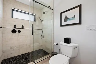 a bathroom with a shower stall and a toilet at Estes Dream! Brand New End Unit with Two Patios, Indoor/Outdoor Fireplace and Jacuzzi in Estes Park