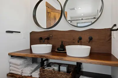 a bathroom with two sinks and a mirror at Estes Dream! Brand New End Unit with Two Patios, Indoor/Outdoor Fireplace and Jacuzzi in Estes Park