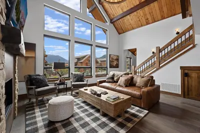 a living room with a couch and a table at Elk Haven! Two Large Patios, Private Jacuzzi, Indoor/Outdoor Fireplace in Estes Park