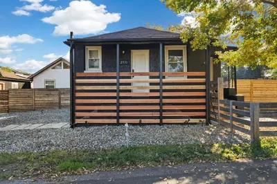 a small house with a fence in front of it at Peaceful Home w/ 4BR, Big Yard and amazing art in Denver