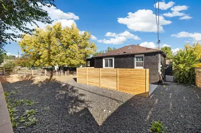 a wooden fence in front of a house at Peaceful Home w/ 4BR, Big Yard and amazing art in Denver