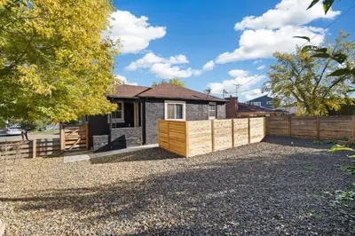 a house with a wooden fence in front of it at Peaceful Home w/ 4BR, Big Yard and amazing art in Denver