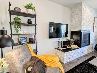 a living room with a couch and a fireplace at HostWise Stays - The River West - Hot Tub, Parking, Fire Pit, and more in Silverthorne