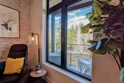 a room with a window with a chair and a table at HostWise Stays - The River West - Hot Tub, Parking, Fire Pit, and more in Silverthorne