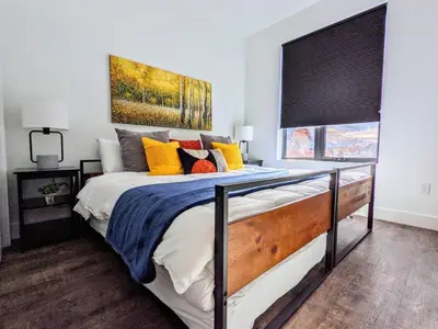 a bedroom with a large bed with colorful pillows at HostWise Stays - The River West - Hot Tub, Parking, Fire Pit, and more in Silverthorne