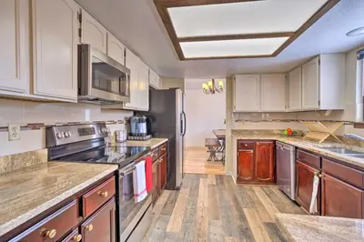 a kitchen with stainless steel appliances and wooden cabinets at Family-Friendly Aurora Vacation Rental with Yard! in Aurora