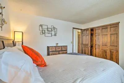 a bedroom with a large white bed with an orange pillow at Family-Friendly Aurora Vacation Rental with Yard! in Aurora