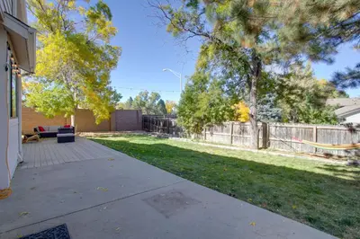 a backyard with a fence and a yard with grass at Family-Friendly Aurora Vacation Rental with Yard! in Aurora
