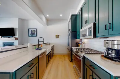 a kitchen with green cabinets and white counter tops at Eagle Ridge Retreat in Granby