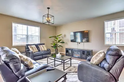 a living room with leather furniture and a tv at 10 Mi to DIA Spacious Aurora House with Yard! in Aurora