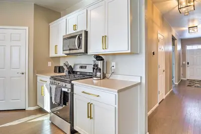 a kitchen with white cabinets and a stove top oven at 10 Mi to DIA Spacious Aurora House with Yard! in Aurora