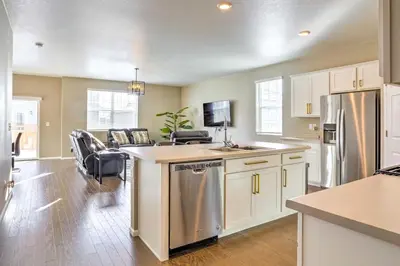 a kitchen with white cabinets and a stainless steel refrigerator at 10 Mi to DIA Spacious Aurora House with Yard! in Aurora