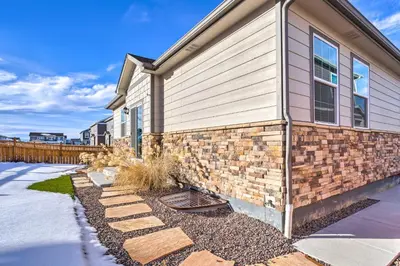 a home with a stone walkway next to a house at 10 Mi to DIA Spacious Aurora House with Yard! in Aurora