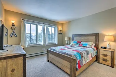 a bedroom with a bed and a tv and windows at Granby Home Stunning Mountain and Lake Views! in Granby