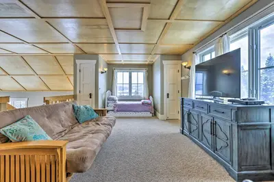 a living room with a couch and a flat screen tv at Granby Home Stunning Mountain and Lake Views! in Granby