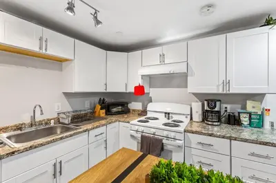 a kitchen with white cabinets and a sink at Basement with Full Kitchen and Near Downtown in Denver
