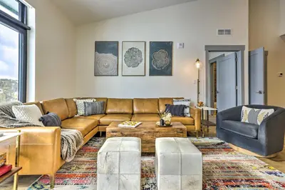 a living room with a brown couch and a table at Condo with Mountain Views in Heart of Downtown! in Winter Park