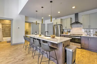 a large kitchen with a large island with bar stools at Condo with Mountain Views in Heart of Downtown! in Winter Park