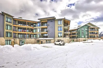 a car parked in the snow in front of a building at Condo with Mountain Views in Heart of Downtown! in Winter Park