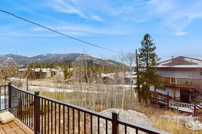 a balcony of a house with a view of the mountains at The Golden Moose Chalet in Grand Lake
