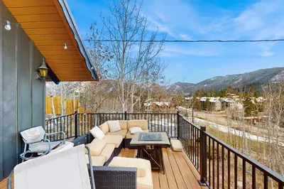 a balcony with a couch and a table and chairs at The Golden Moose Chalet in Grand Lake