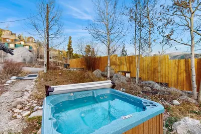 a hot tub in a yard with a fence at The Golden Moose Chalet in Grand Lake