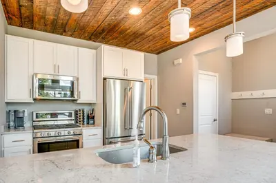 a kitchen with white cabinets and a stainless steel refrigerator at 6 Mi to Winter Park Resort Home with Free Shuttle in Winter Park
