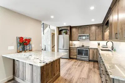 a kitchen with wooden cabinets and marble counter tops at Mount Royal in Frisco
