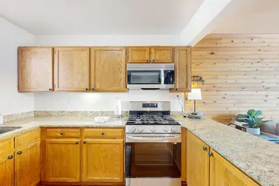 a kitchen with wooden cabinets and a stove and microwave at Grand Lake Lookout in Grand Lake