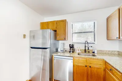 a kitchen with a white refrigerator and wooden cabinets at Grand Lake Lookout in Grand Lake
