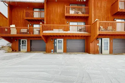 a building with two garage doors in the snow at Grand Lake Lookout in Grand Lake