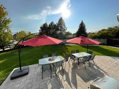 a patio with two tables and red umbrellas at Sleeps 12 - Thornton - 25 Min to Downtown Denver in Thornton