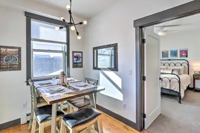 a dining room with a table and chairs and a bedroom at Modern Mountain Getaway, Walk to Grand Lake! in Grand Lake