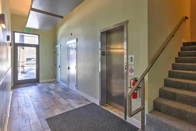 a hallway with stairs and a door and a stair case at Modern Mountain Getaway, Walk to Grand Lake! in Grand Lake
