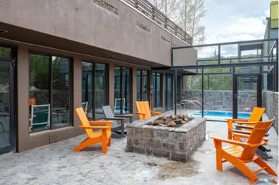 a patio with chairs and a fire pit and a pool at Snowblaze E102 Studio in Winter Park