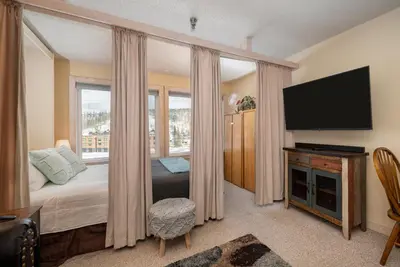 a bedroom with a bed and a flat screen tv at Snowblaze E102 Studio in Winter Park