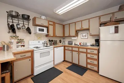 a kitchen with white appliances and wooden cabinets at Snowblaze E102 Studio in Winter Park