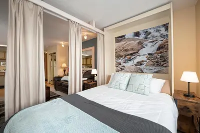 a bedroom with a bed with a painting on the wall at Snowblaze E102 Studio in Winter Park