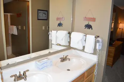 a bathroom with two sinks and a large mirror at Beaver Village Unit #0521R in Winter Park