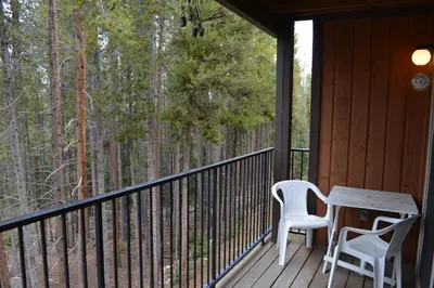 a porch with two chairs and a table on it at Beaver Village Unit #0521R in Winter Park