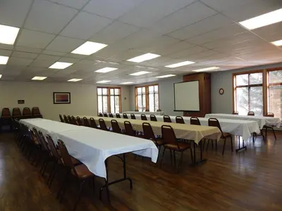 a conference room with tables and chairs and a screen at Beaver Village Unit #0521 in Winter Park