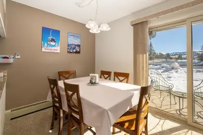 a dining room with a table and a balcony at Meadow Ridge Court 9 Unit 4 in Fraser