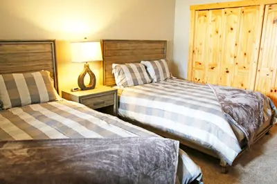 a bedroom with two beds and a wooden cabinet at Meadow Ridge Court 8 Unit 6 in Fraser