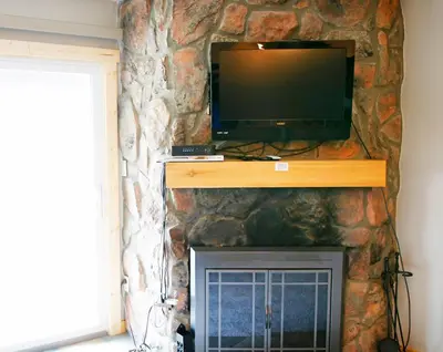 a flat screen tv sitting on top of a stone fireplace at Meadow Ridge Court 8 Unit 6 in Fraser