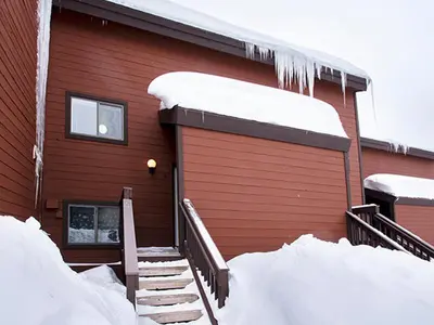 a red house with snow on the side of it at Meadow Ridge Court 28 Unit 6 in Fraser