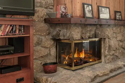 a stone fireplace with a fire in it at Beaver Village Unit #0232R in Winter Park