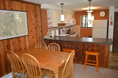 a kitchen with a wooden table and wooden chairs at Beaver Village Unit #0612 in Winter Park