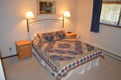 a bedroom with a bed with two night stands and two lamps at Beaver Village Unit #0612 in Winter Park