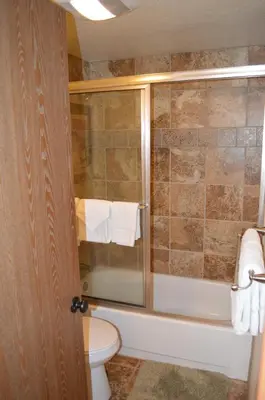 a bathroom with a toilet and a shower with towels at Beaver Village Unit #0612 in Winter Park